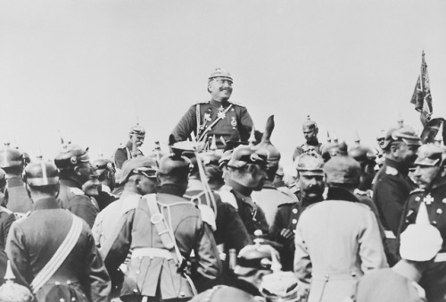 “The Kaiser, on horseback, photographed smiling and surrounded by his men during the manoeuvres of 1
