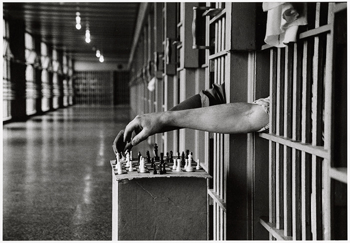 history-inpictures:  Two inmates, one black and one white, playing chess from between