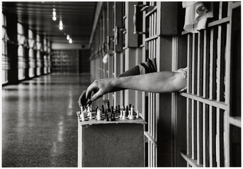 history-inpictures: Two inmates, one black and one white, playing chess from between the bars of the