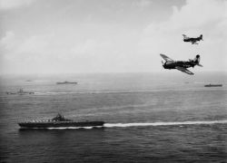 sailnavy:    Two U.S. Navy Curtiss SB2C-4 Helldiver dive bombers of Bombing Squadron 83 (VB-83) fly against the backdrop of ships of Task Group 38.3 operating off Okinawa. VB-83 operated from USS Essex (CV-9), pictured in foreground, during the period
