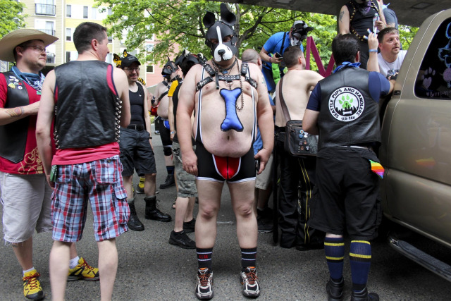 person in a puppy mask and exposed belly stands looking at camera at a Seattle pride event