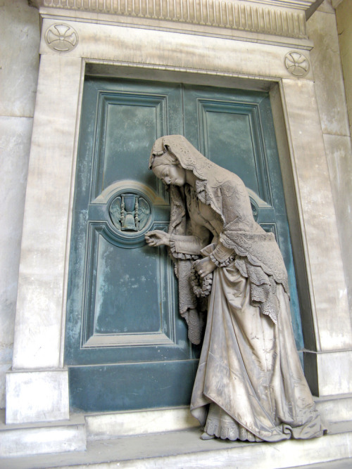 Sculpture of a woman knocking on a door from the tomb of Pietro Badaracco in Staglieno Cemetery by G