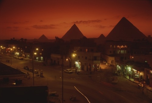 ritsual: Kenneth Garrett, NAZLET EL SAMMAN, EGYPT. Nazlet el Samman and nearby Giza pyramids at suns