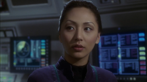 [ID: a screenshot of Hoshi Sato from Star Trek Enterprise. She’s shown from the shoulders up, lookin