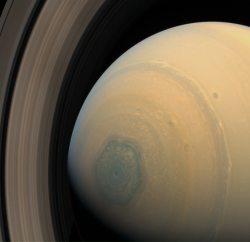 sci-universe:  Saturn’s hexagon is a persisting six sided cloud pattern around the north pole of the planet. It is created by a band of upper-atmospheric winds, and the sides of it are about 13,800 km (8,600 mi) long, which is longer than the Earth’s