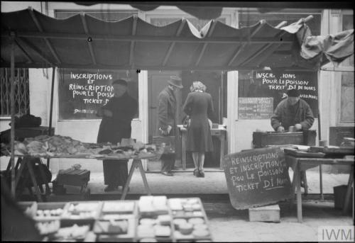 Everyday life in liberated Paris (spring 1945):A large group of civilians queueing outside a bakery-