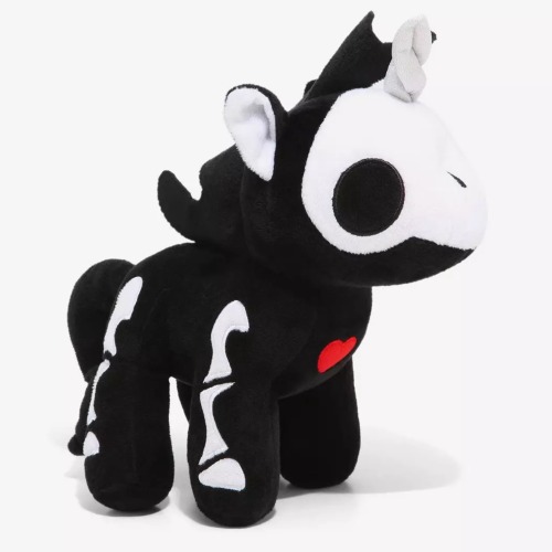A stuffed animal of a black unicorn with a white skeleton. The bones are cartoony and simple. There is a small red heart in the middle of its chest.