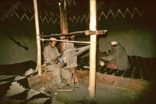 Shimshal, Pakistan.40 years old weaver Shanazar on the loom and his mother on the spinning wheel (19