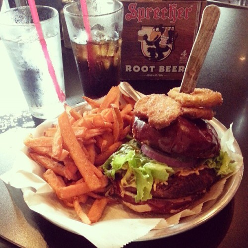 veganlucifer:  this was my lunch earlier at Stack’d burger bar earlier today. black bean burger, vegan cheddar, raw veggies, fried pickles, on a pretzel bun with sweet potato fries. died and went to #vegan heaven. 