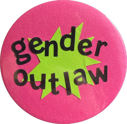 a pink pin with a yellow star in the center and black text reading 'gender outlaw'