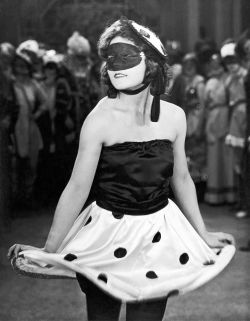  A woman wearing a mask at a costume party. United States, 1928 