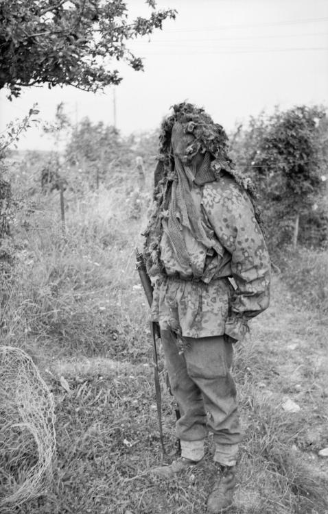 grehtsteinmann:  A sniper demonstrates his camouflage at a sniper school in a French village 27 July 1944. 