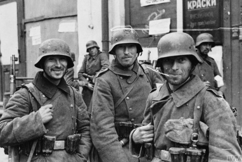 Three German Landsers, or infantry soldiers, smile for thecamera in a Russian town (mid- to late 194