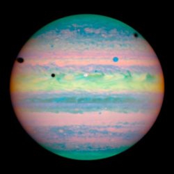 astronomyblog:  astronomyblog: In this composite image from near-infrared light, two of Jupiter’s moons are visible against the planet. The white circle in the middle of Jupiter is Io, and the blue circle at upper right is Ganymede. The three black