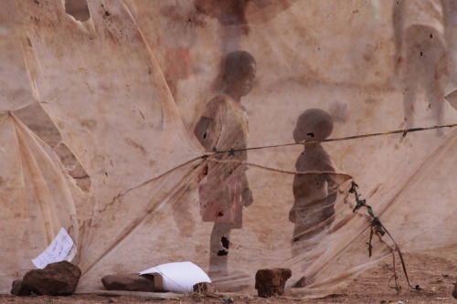 unrar:   Children are seen through a mosquito net used as goal post net on the outskirts of Lusaka, Zambia on November 10, 2014. (Moses Mwape/AP) 