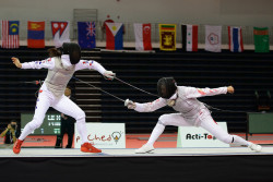 Modernfencing:  [Id: Two Foilists Lunging At Each Other.] Jeon Hee Sook (Left) Against