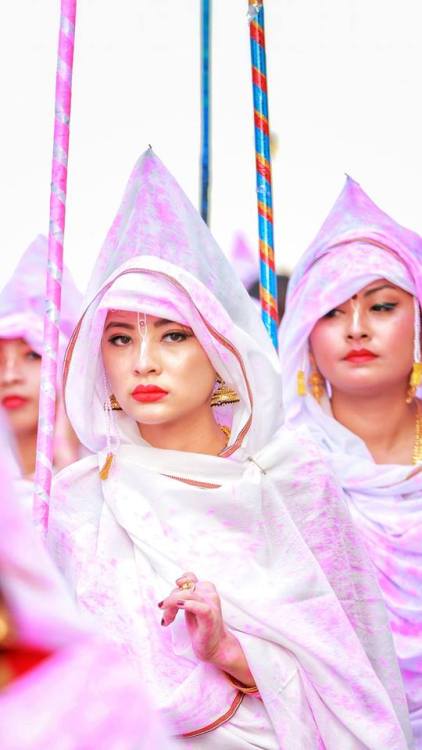 Beautiful veiled woman protecting themselves from the colored powders, Holi Festival at Radha Govind