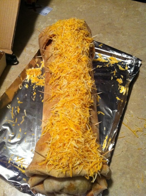 foodhumor:  Meet the burrito-filled bacon pizza burrito. Yes, that’s right: Some gluttonous/stoned genius managed to wrap two pounds of bacon and three chipotle burritos within a large cheese pizza. The pizza burrito then is topped with more cheese