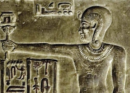  the Child-God Ihy (wearing the skullcap with the Uraeus and the sidelock of youth) playing the sist