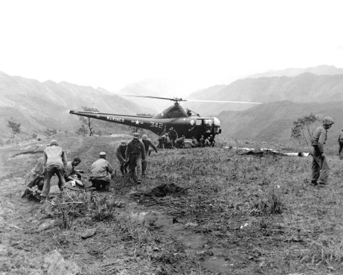 Navy Corpsmen prepare threee Marines wounded on Kari San Mountain for medevac via a Sikorsky H-5 hel