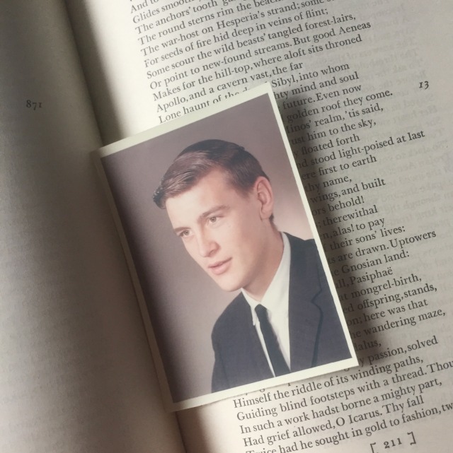 a picture of an open book. in the pages there is an old photograph of a man in a suit
