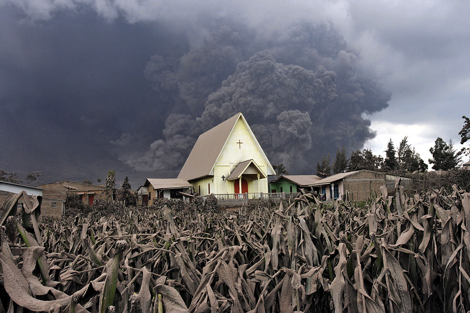 Mount Sinabung erupts behind a church in Sibintun, Indonesia (Photo by Binsar Bakkara/AP via Framework)