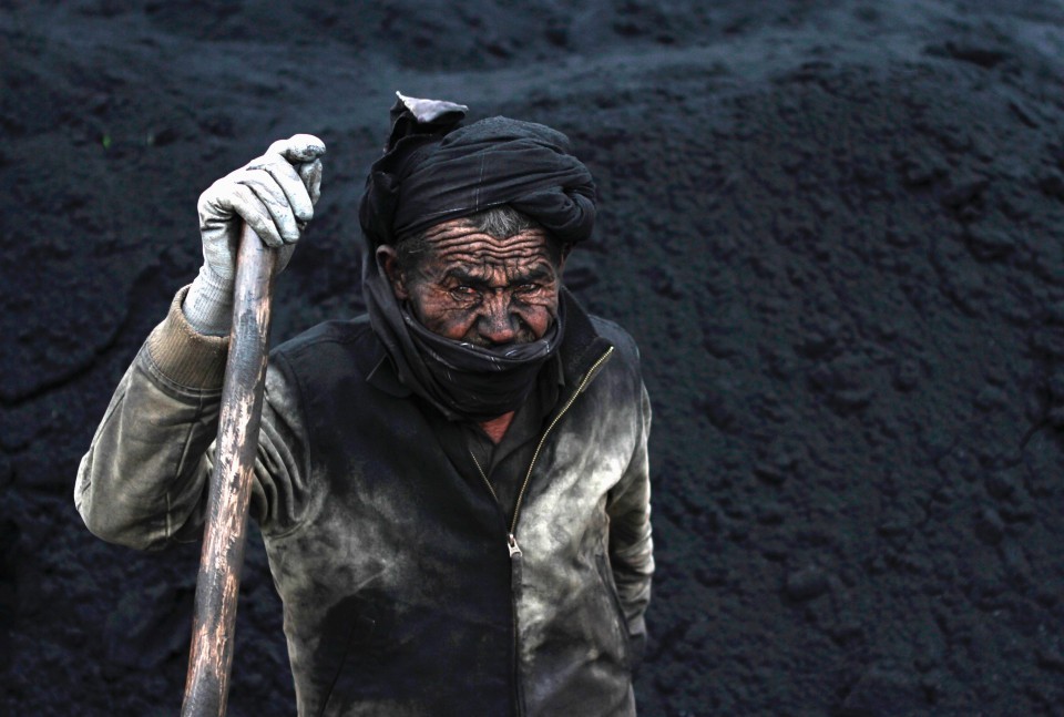 fotojournalismus:  A labourer takes a break at a coal dump site outside Mazar-i-Sharif,