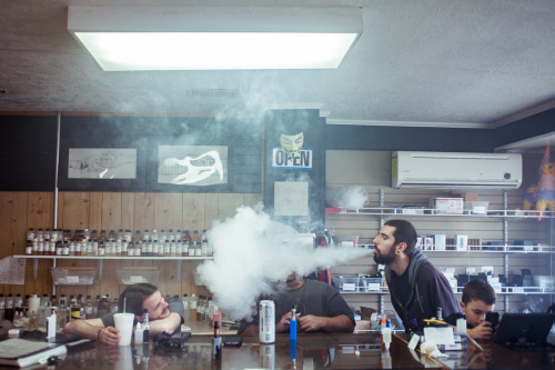 Andrew Taylor, left, Aaron Combs, Andrew Shelton, and his son hang out at Tapering Vapor, a vape sho