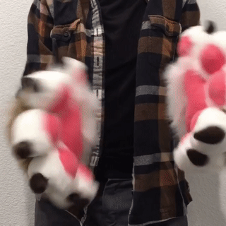brown and white cuffs with pink pawpads. the person wearing them wiggles their fingers