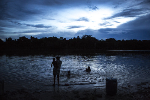 Xikrin men, women, and children gather on the banks of the Bacaja River at the end of a hot Amazonia