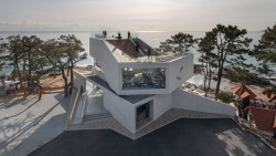 archatlas:      Waveon Cafe in Gijang This coastal cafe in the South Korean city of Gijang comprises a series of enormous concrete volumes that dwarf neighboring houses, and are stacked and rotated to optimise views of the East China Sea.Seoul studio