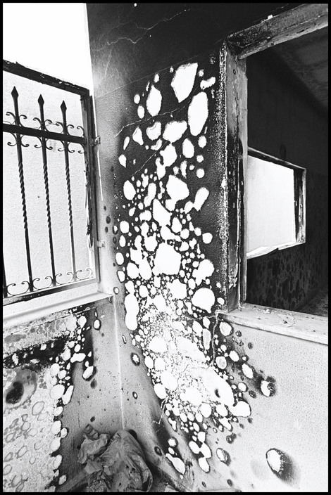realityayslum:  Larry Towell  ISRAEL. Jenin Refugee Camp. Occupied West Bank . May 2002. Wall burned and blistered from incendiary blast. 