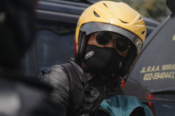 Motorist looks on as he navigates the traffic. Bandung, Indonesia