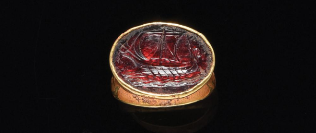 A hellenistic gold ring set with a garnet intaglio with a roman vessel (if one interprets a ram at the bow that is it a warship, if not then it is a merchant vessel) of the 2nd - 1st century B.C. #naval artifacts#roman ring#garnet intaglio#roman vessel #2nd-1st century bc #ancient seafaring