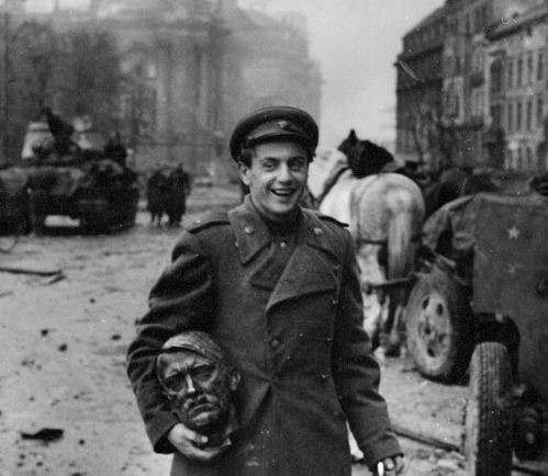 Soviet soldier carrying the head of a statue of Hitler, Berlin 1945. Photograph by