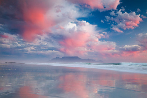 Ghost rain hanging from the clouds catches the sunset light over Table Bay on an eerie winter’s day.