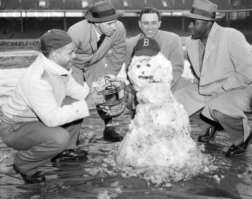 oldtimefamilybaseball:  Is this Jackie Robinson and the Brooklyn Dodgers admiring their (quite terrible) snowman?  Or is it actually a group of police detectives observing a horrific crime scene where a man has been reduced to nothing but white ash and