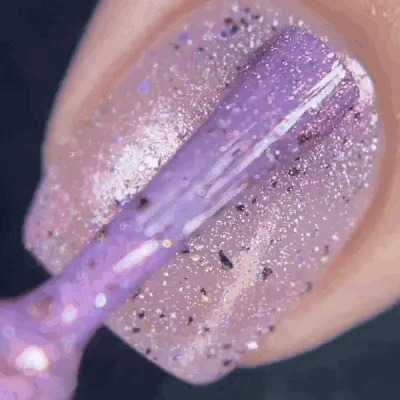 lavender nail polish with silver glitter being applied