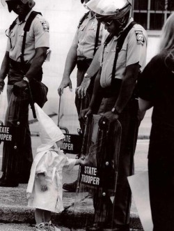 zevksiz:  &ldquo;The child of a KKK member touches his reflection in an African American police officer’s riot shield during a demonstration. [1992]&rdquo;