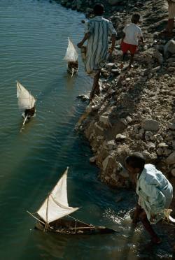 natgeofound:  Boys play with toy sailboats