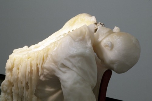 asylum-art:  Tatiana Blass’s Wax Figures Melt  Tatiana Blass built a human body that leans over the spine of a chair. She built this body out of wax and gave it a spotlight to shine; however, its glow not only illuminated, but also curdled the figure’s