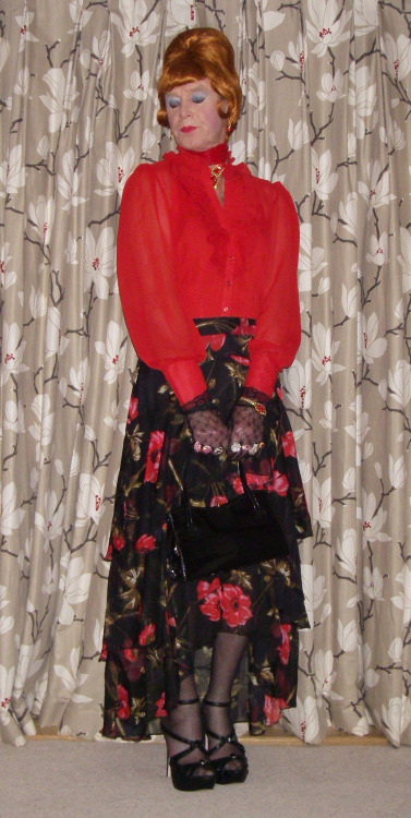 Red frilly chiffon blouse with a flounced chiffon skirt. Beehive wig and stiletto heels. Blouse and 