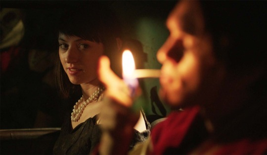 Still shot in close-up of woman looking at a man lighting a cigarette