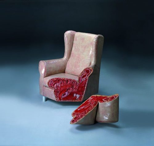 Image of sculpture of a living room chair the corner of which is cleanly cut. The exterior of the chair resembles human skin while the insides look like organs.