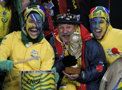 Trivia from the “sad guy with a mythical moustache holding the World Cup trophy”, and some happy pictures of him! His name is Clovis Acosta Fernandes, also known as “Gaúcho da Copa”. He’s 59 years old and works as a real