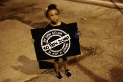 yearningforunity:  A girl holds a sign during