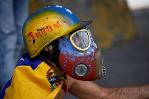  A demonstrator looks on while clashing with riot security forces during a rally against Venezuela&r