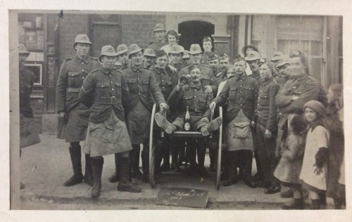 ….At the edge of a group shot a child in a woollen hat stares into the camera.She looks tro