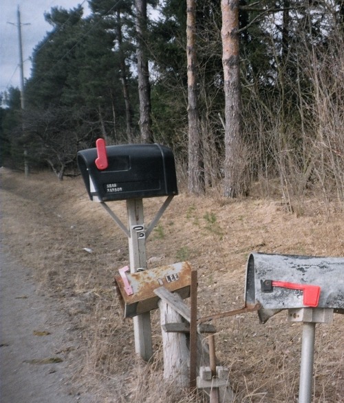 mailboxes outside of an abandoned tenant house across the street from a graveyard. the tenant house 