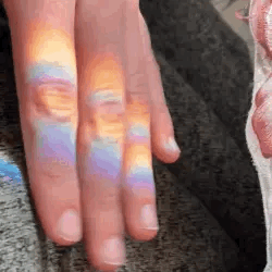 tapping fingers with rainbow reflection gif 